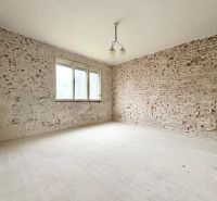 Room in a family house with brick walls and a simple chandelier.