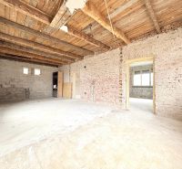 Interior of a family house with exposed bricks and a wooden ceiling.