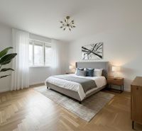 Bright bedroom in a family house with wood-patterned flooring and a houseplant.