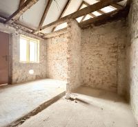 Interior of a family house with unplastered brick walls and raw concrete floor.