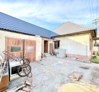 A family house in Šoporňa with two roofs and an unkempt yard.