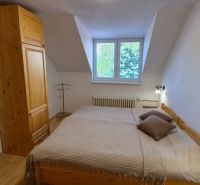 A bedroom in a 2-room apartment with wooden furniture and a wooden decor floor.