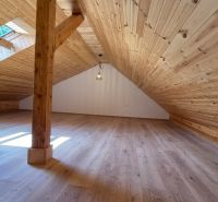 Attic space with wooden paneling and wood-patterned flooring in a 2-room apartment.