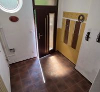 An entrance hall with tiled flooring and a decorative round window in a 2-room apartment.