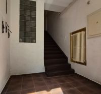 Hallway of a staircase in a 2-room apartment with ceramic tiles and stairs.