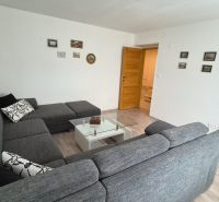 Living room in a two-room apartment with a comfortable sofa and a glass table.