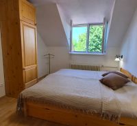 A bedroom with wooden furniture and a floor with a wooden decor in a 2-room apartment.