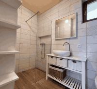 A bathroom with ceramic tiles and a wooden decor floor in a family house.