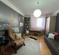 Living room in a family house with a wooden decor floor and a large Eiffel Tower on the wall.