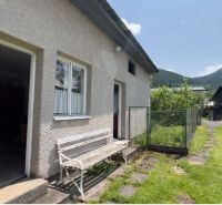 A family house in Liptovská Lúžna with a bench and a picturesque view of the hills.