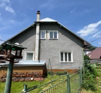 A family house in Liptovská Lúžna with a landscaped garden and a bird feeder.