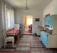 Interior of a family house with a kitchen unit, dining table, and wooden floor decor.