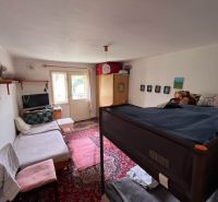 A room in a family house with a bunk bed, carpet, and a TV on a shelf.