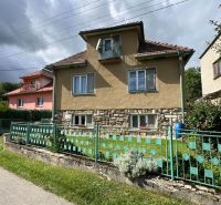 A family house in Kalameny, with a stone foundation and a colorful fence.