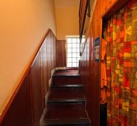 A stylish hallway with wooden paneling and a fabric curtain in a family house.