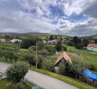 A view of family houses in Kalameny amidst green landscape and hills.