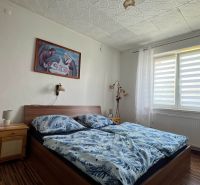 A bedroom in a 3-room apartment with a bed and a picture on the wall.