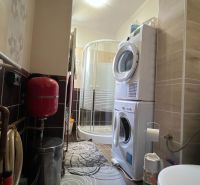 Bathroom in a 3-room apartment with a washing machine, shower, and installations.