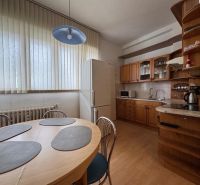 A kitchen in a 3-room apartment with a wooden decor floor and a dining table.