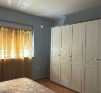 Bedroom in a family house with a white wardrobe and a wooden decor floor.