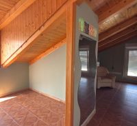 Interior of a family house with a wooden decor floor and a sloped ceiling.