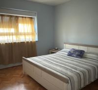 A bedroom in a family house with two windows and a wooden decor floor.