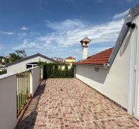 A terrace with a view of family houses in Ražanac, with tiles and white doors.
