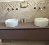 Double sinks on a dark countertop with tiles in a family house.