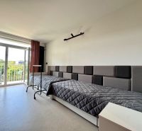 Studio apartment with a bed, armchairs, and large windows, in Košice on Kysucká.