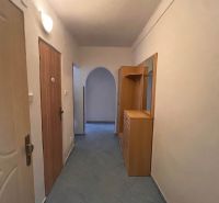 A hallway with tiles, built-in furniture, and an arched passageway in a 2-room apartment.