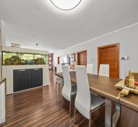 Dining room in a family house with an aquarium and a wooden decor floor.