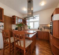 A kitchen in a 4-room apartment with a wood decor, centrally located island.