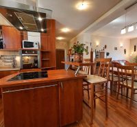 Kitchen and dining room in a 4-room apartment with wood decor and modern furnishings.