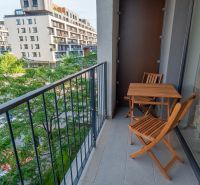 The balcony of a 1-room apartment on Zuzany Chalupovej Street, Bratislava - Petržalka with wooden furniture.