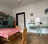A kitchen in a family house with retro furniture and a wooden decor floor.