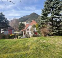 A family house on Makovického Street in Ružomberok, surrounded by greenery and mountains in the background.