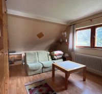 Interior of a family house with a sofa, a table, and a wooden decor floor.