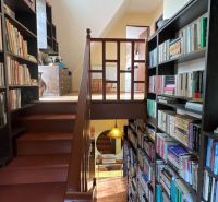 A staircase and shelves full of books in a family house with a wooden decor floor.