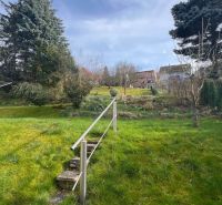 Garden of a family house on Makovického Street in Ružomberok with a lawn and trees.
