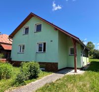 A family house in Polomka with a light-colored facade and a well-maintained garden.