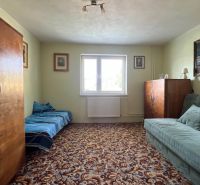 A room in a family house with retro-style furniture and a decor carpet.