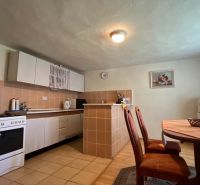 Kitchen in a family house with a dining table, oven, and refrigerator.