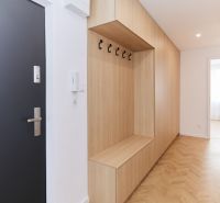 A hallway with built-in furniture and a floor with a wooden decor in a 4-room apartment.