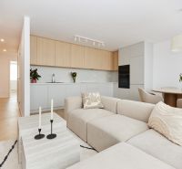 A spacious living room in a 4-room apartment with a kitchenette and a floor with a wooden decor.