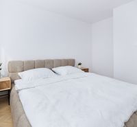 A bright bedroom with a light bed and nightstands in a 4-room apartment.
