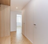 A hallway in a 4-room apartment with a wooden decor floor and a built-in wardrobe.
