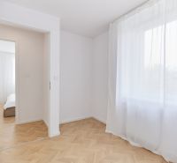 A room with white curtains and a wooden decor floor in a 4-room apartment.