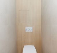 A toilet with a wooden decor floor in a 4-room apartment.