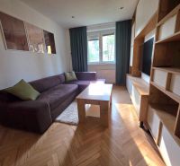 Living room in a two-room apartment with a comfortable sofa and a wooden decor floor.