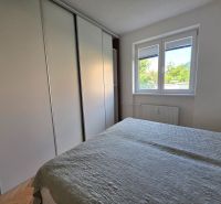 Bedroom with a built-in wardrobe and a window in a 2-room apartment.